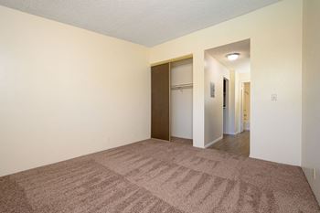A bedroom with a carpeted floor and white walls